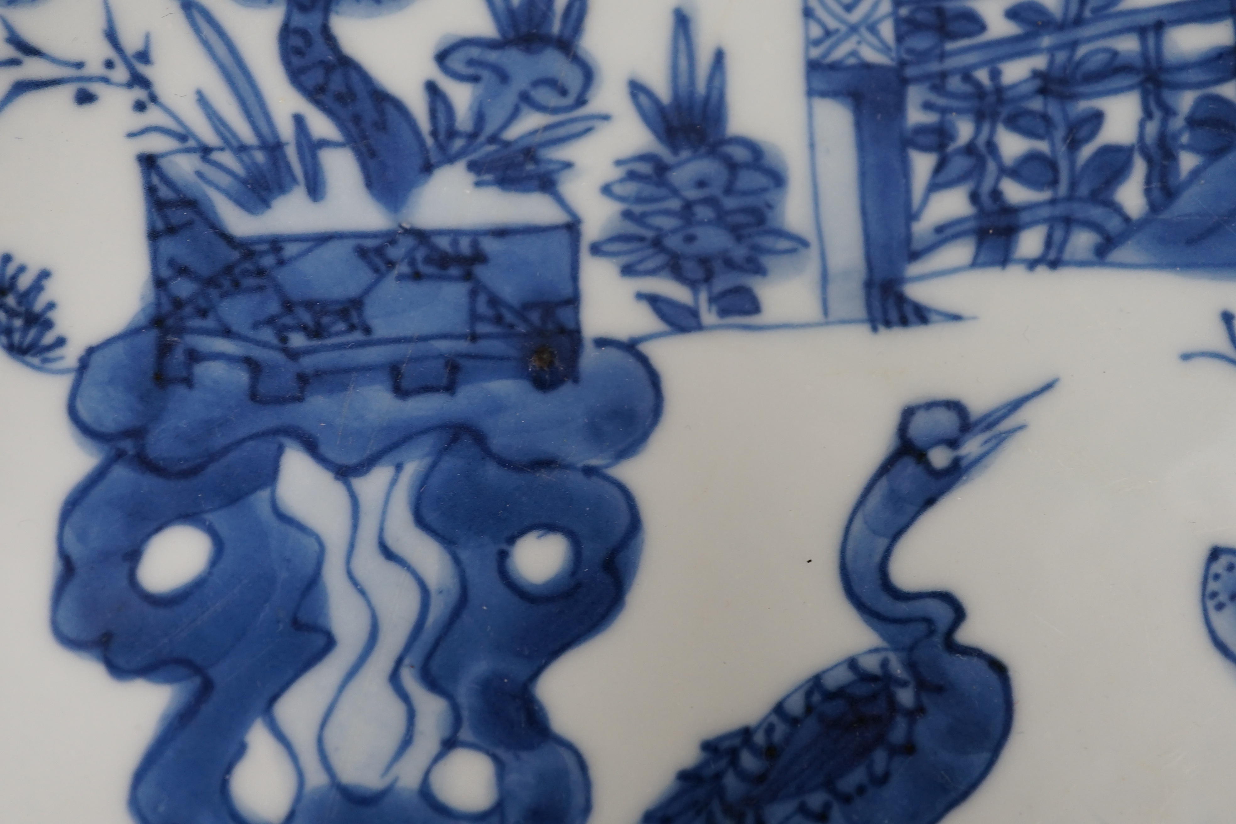 A pair of Chinese blue and white ‘garden’ dishes, Kangxi period, fritting and glaze chips